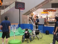 写真：車いすに乗りバスケットボールのゴールをする女性