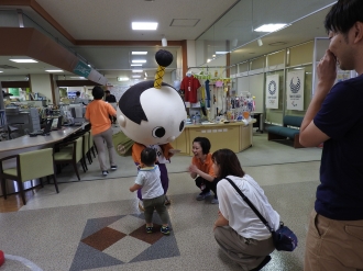 写真：はち丸君と握手している様子